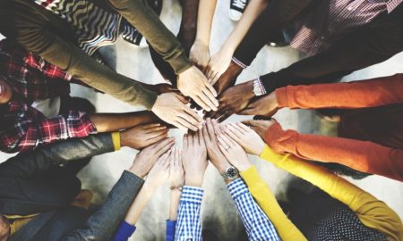 community organizing, development, cultural diversity grants: group of people putting hands in circle