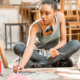 Black, Indigenous and People of Color Arts and culture support Grants; young black woman painting on floor