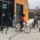 bike: 6 kids on bikes in front of glass-front building