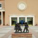 Child abuse New Mexico called into question: photo of New Mexico State Capitol with bronze statue of kids playing in front