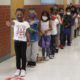 Education funding New Mexico elections: young school students lining up in school hallway