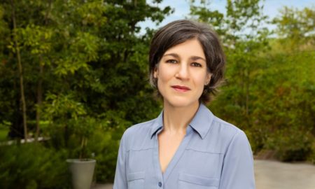 Rebecca Benghiat: short-haired white woman in light blue-grey shirt standing outside