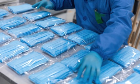 COVID-19 in juvenile facilities: worker with packaged masks for distribution