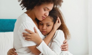 children exposed to domestic violence, family violence grants: mother comforting her young, sad daughter