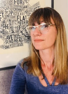 Nebraska abortion: Headshoytof white, long blonde-haired woman with light framed glasses wearing blue top in front of word collage poster.