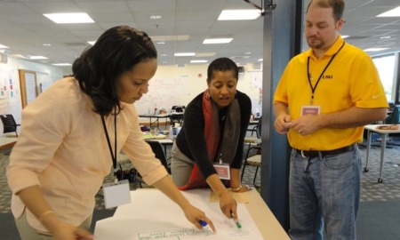 juvenile justice reform leadership team grants: group of people around table pointing to work