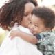 Medicaid funding: Black mother holding Black toddler-aged boy
