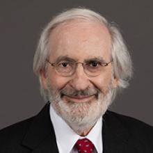 Disabled student programs DOGE cut: Headshot man with white hair and beard in dark suit with white shirt and red tie