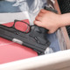 Yout gun deaths: Very young child's hand and arm in red plaid shirt reaches into drawer grabbing a large black gun