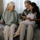 Q&Q Kinship caregivers: Older man and woman both with gray hair sit on couch with young elementary school-age Black girl