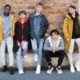 Student reengagement: Five mult-ethnic teens in winter jackets stand in front of brick wall